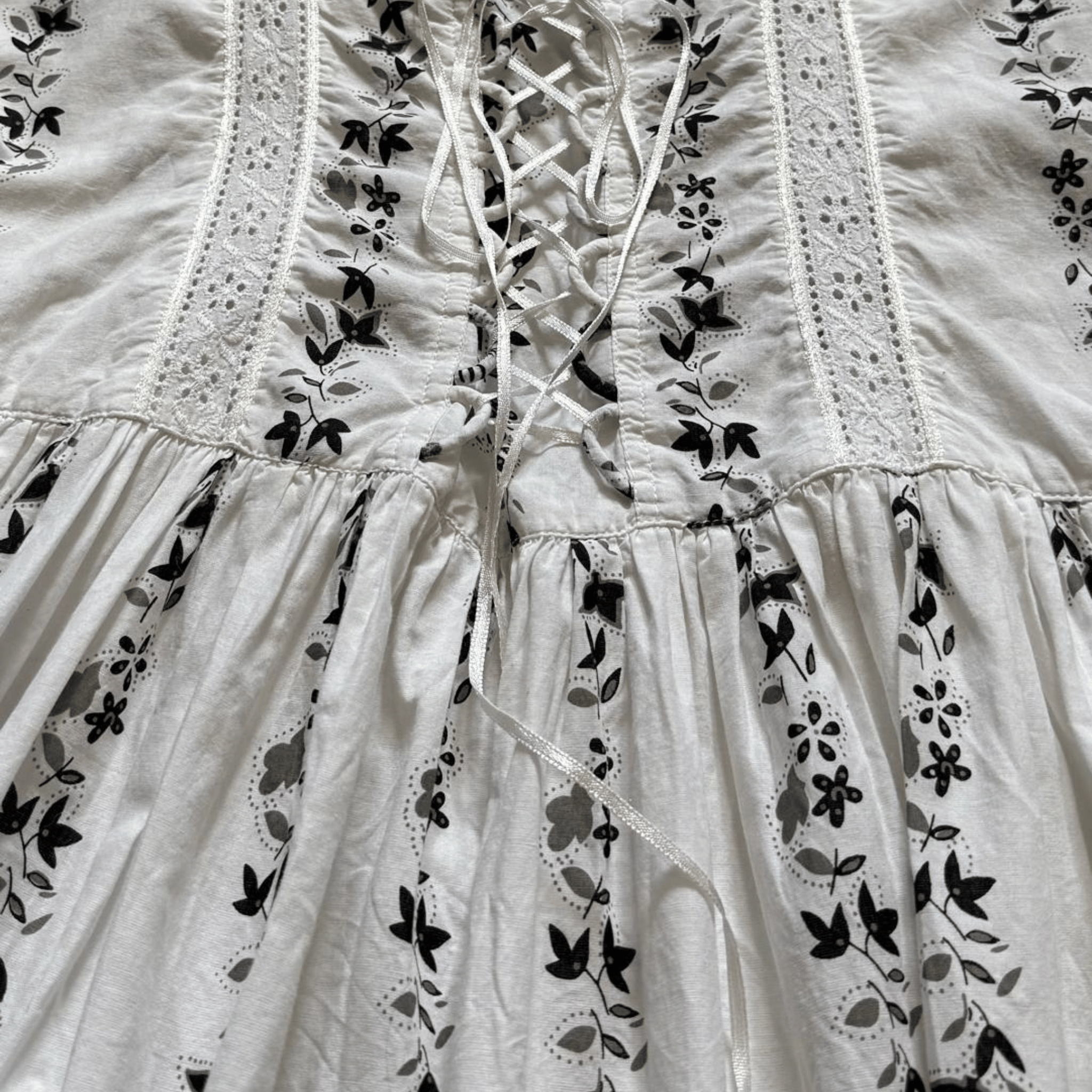White cotton mini dress with straps and a black print