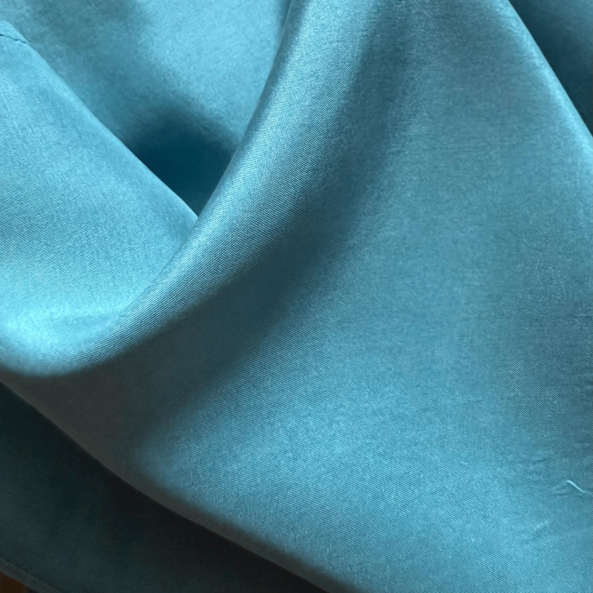 Sleeveless blue silk satin top with a scoop neckline